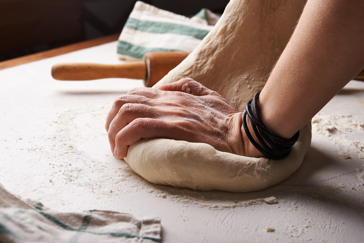 Hands kneading sourdough dough
